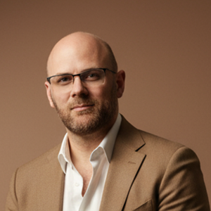 Professional headshot-style portrait of Matt Edwards in a modern workspace, friendly and confident.